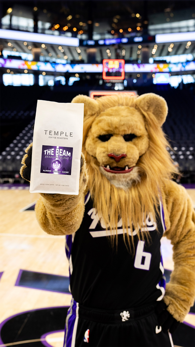 Sacramento Kings mascot Slamson holding The Beam coffee bag courtside at Golden 1 Center